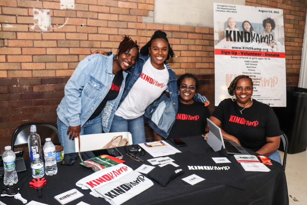 Four young girls at KINDkamp registration desk